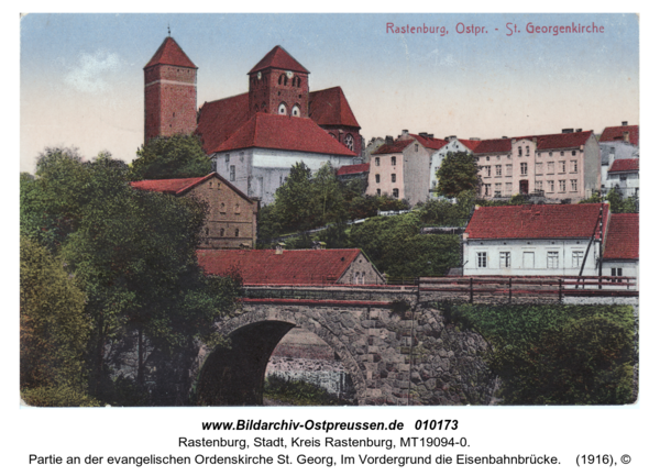 Rastenburg, Partie an der evangelischen Ordenskirche St. Georg, Im Vordergrund die Eisenbahnbrücke