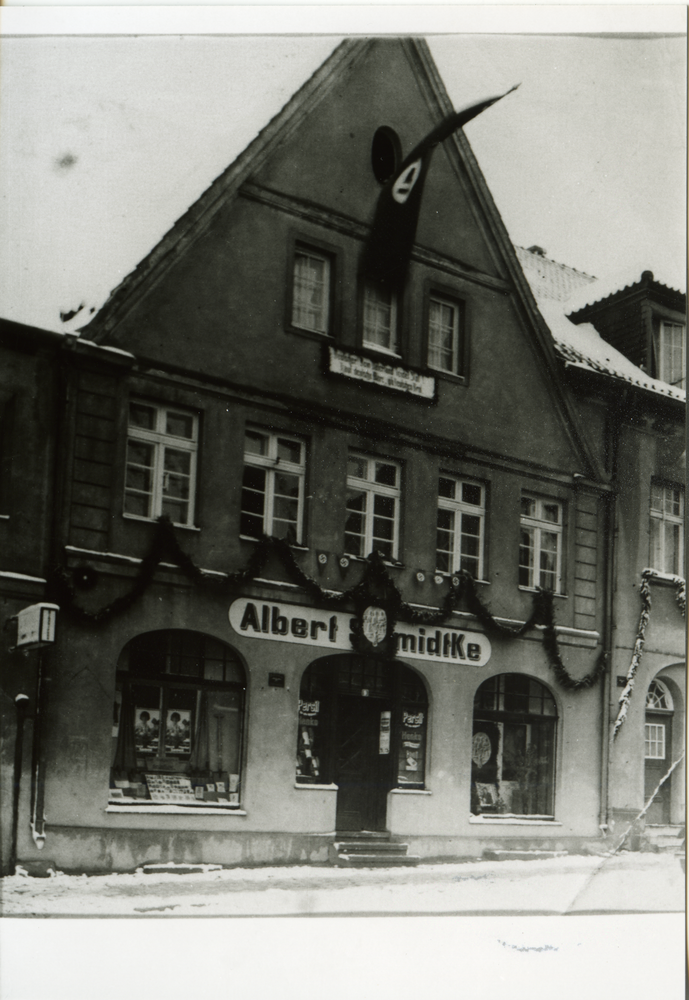 Domnau, Stadt, Geschäft Albert Schmidtke mit Girlandenschmuck - Schnee im Mai