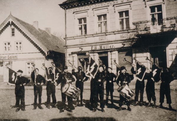 Neukirch, Fanfarenzug vor Friseur-Salon und Geschäft F.H. Müller