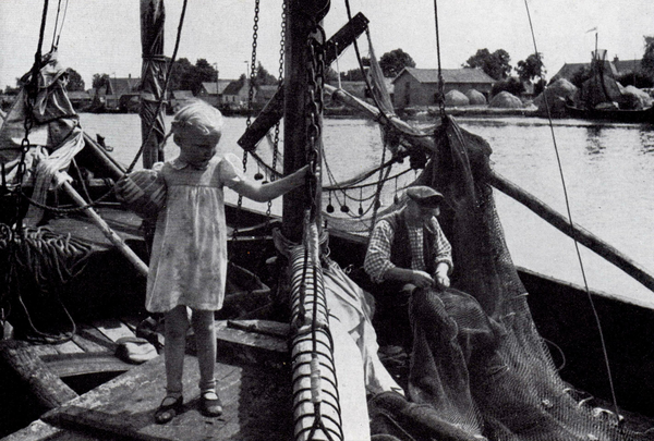 Inse, Fischer beim Flicken der Netze auf seinem Boot
