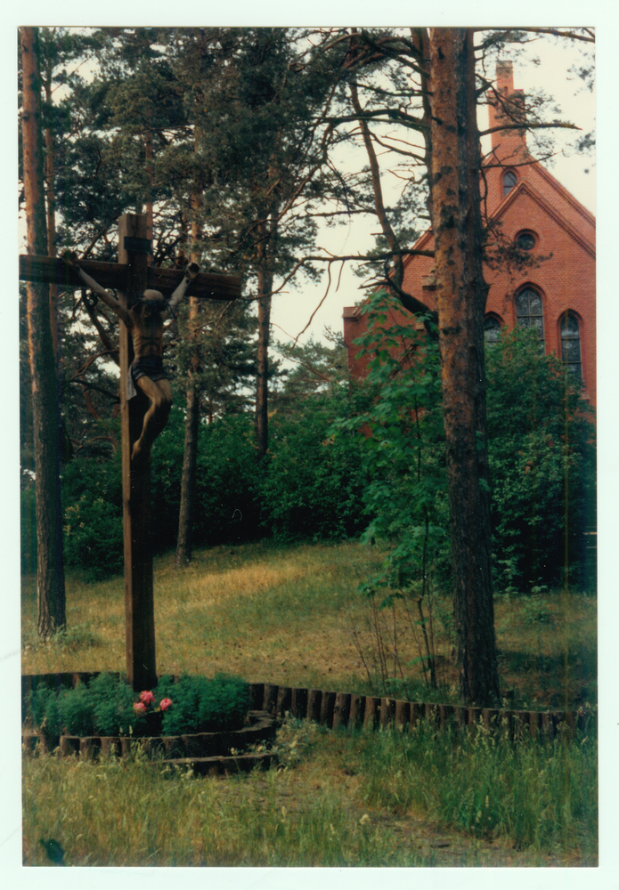 Nidden, Kirche und im Vordergrund ein Kruzifix auf dem Friedhofsbereich